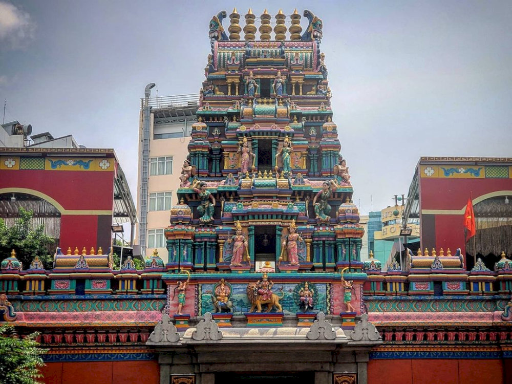 Multi-tiered Gopuram tower decorated with colorful, detailed Hindu deity sculptures